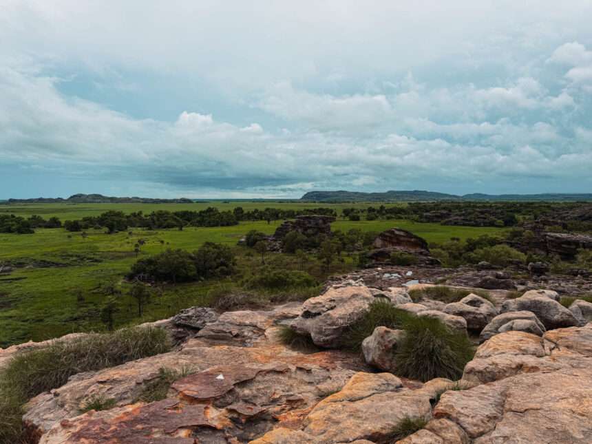 the top of a large rock overlooking a field below - day trips from Darwin