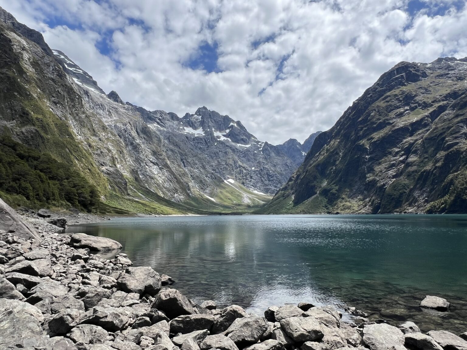An alpine lake nestled between mountains near Milford Sound