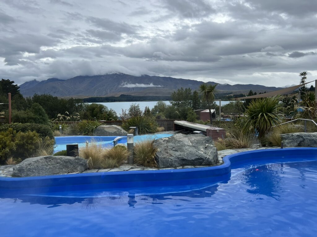 A blue pool overlooking a lake and mountain on a trip from Christchurch to Dunedin
