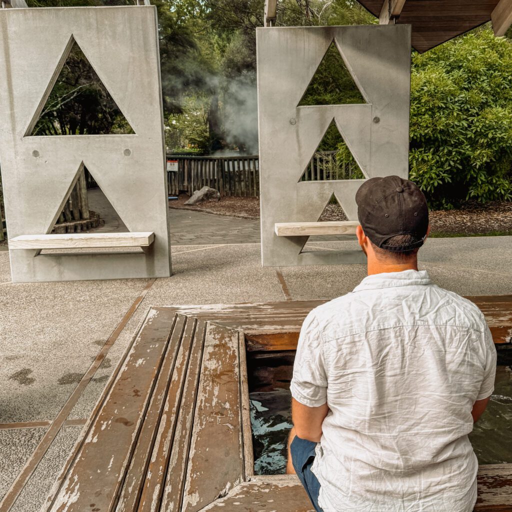 A man with his feet in a public bath in Rotorua