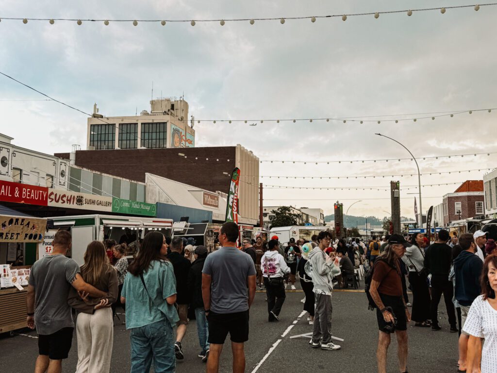 people walking through an outdoor food market in Rotorua