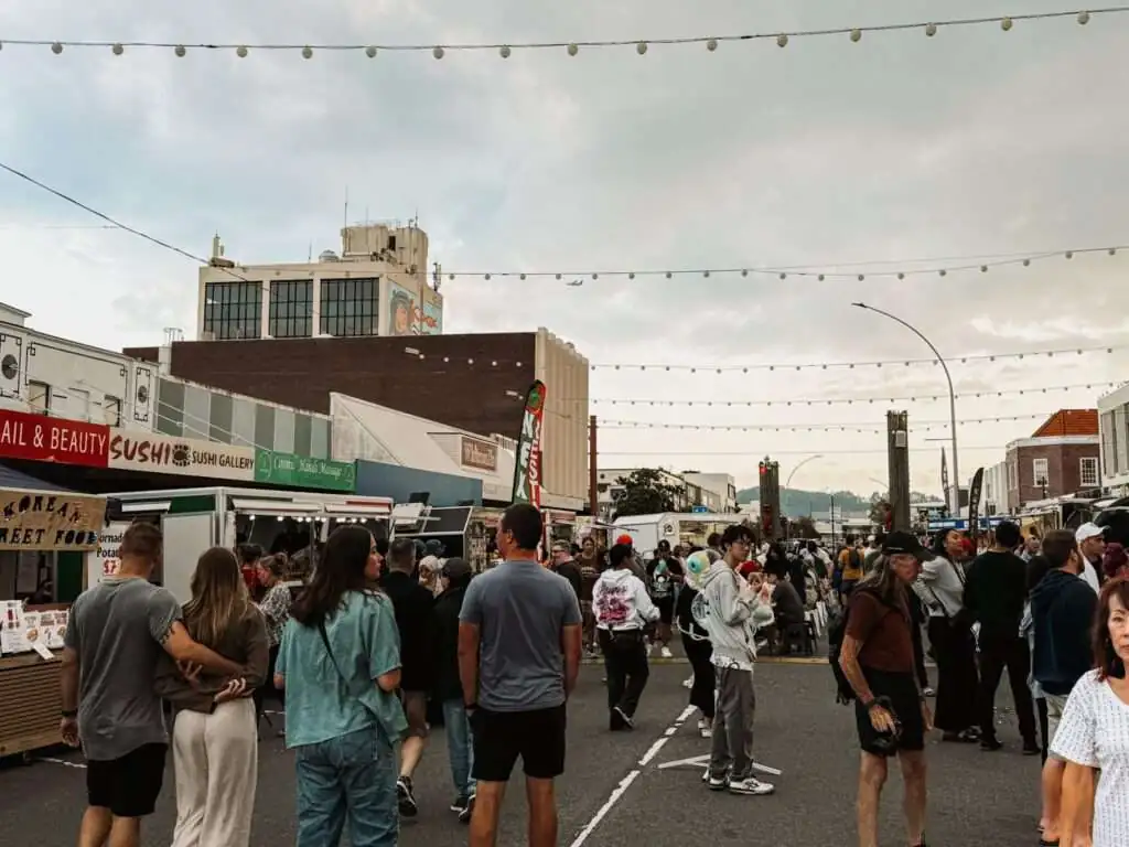 people walking through an outdoor food market as seen in a Rotorua itinerary