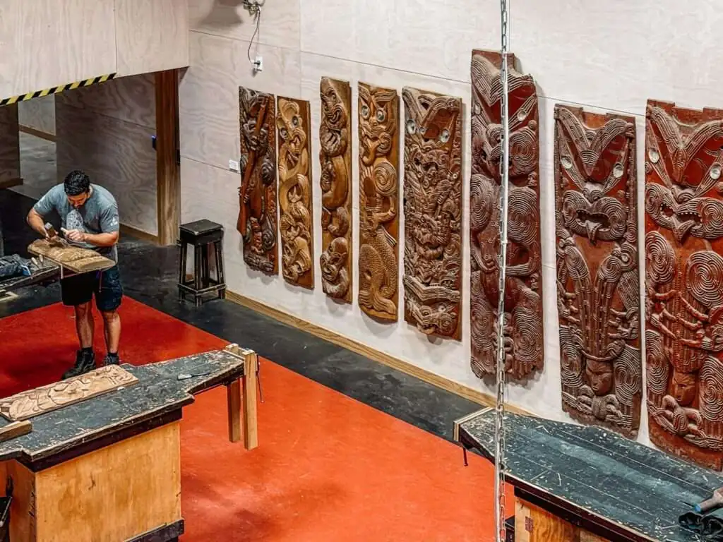 A wood carving studio with wood carvings completed on the wall at a studio as part of a Rotorua itinerary