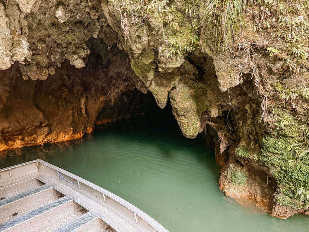 A small boat coming out of a cave outside of Rotorua