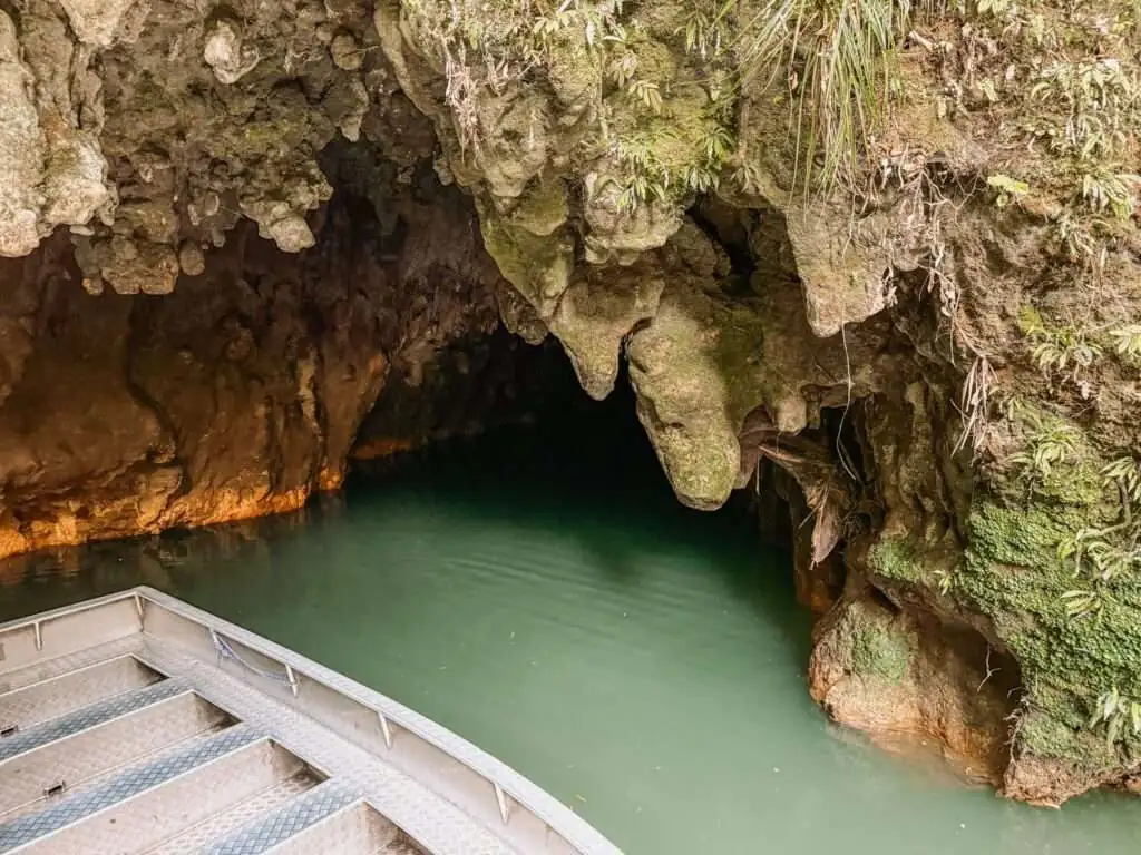 A small boat coming out of a cave and visited as part of a Rotorua itinerary