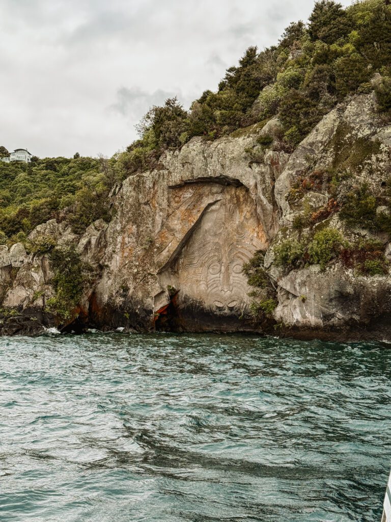 A carving of an abstract face on the side of a stone facade in Taupo