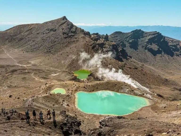Turquoise pools nestled into the valley of a red rocky mountain outside of Taupo on the North Island as one of the top things to do in New Zealand