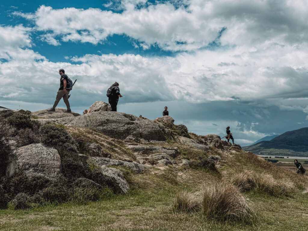 People standing on the top of rocks of a mountain located between Queenstown and Christchurch
