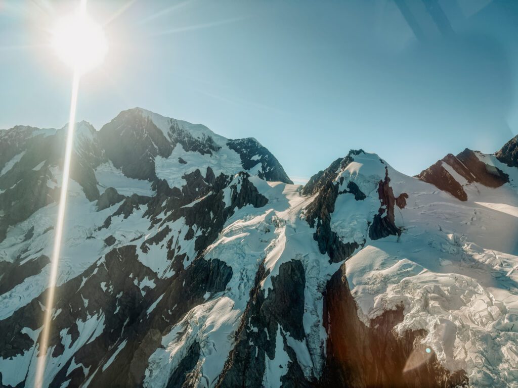 The view of mountain peaks from a helicopter in the West Coast of New Zealand