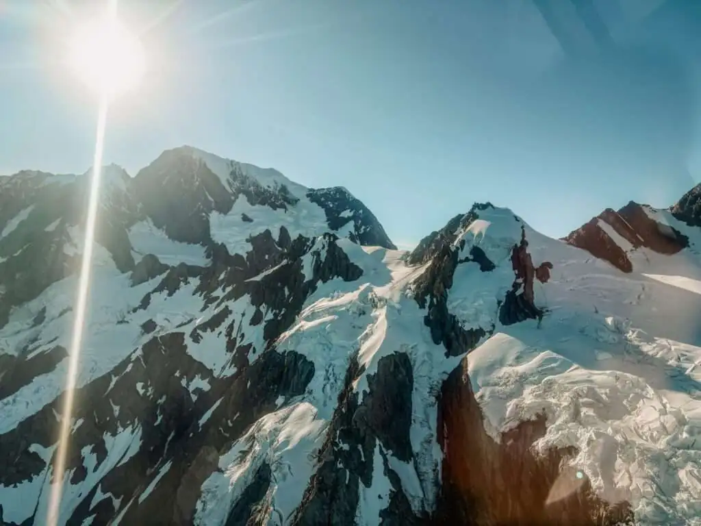 The view of mountain peaks from a helicopter in the West Coast of New Zealand