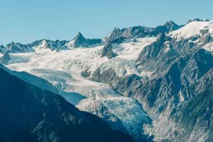 The top of a glacier flowing through mountains as seen from a helicopter on the West Coast of New Zealand
