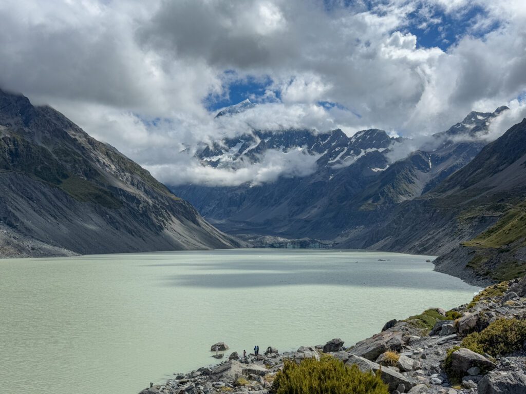 A green lake within mountains in a park between Queenstown and Christchurch