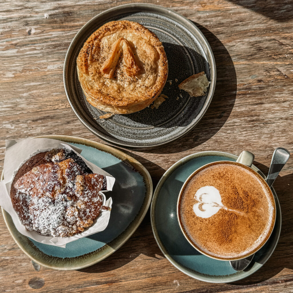 Pastries and coffee on a table from a bakery in a town between Queenstown and Christchurch