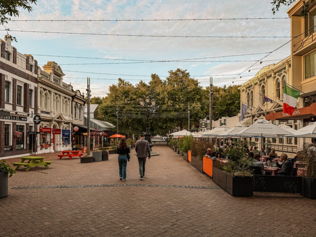 People walking down a pedestrian street with restaurant awnings on either side