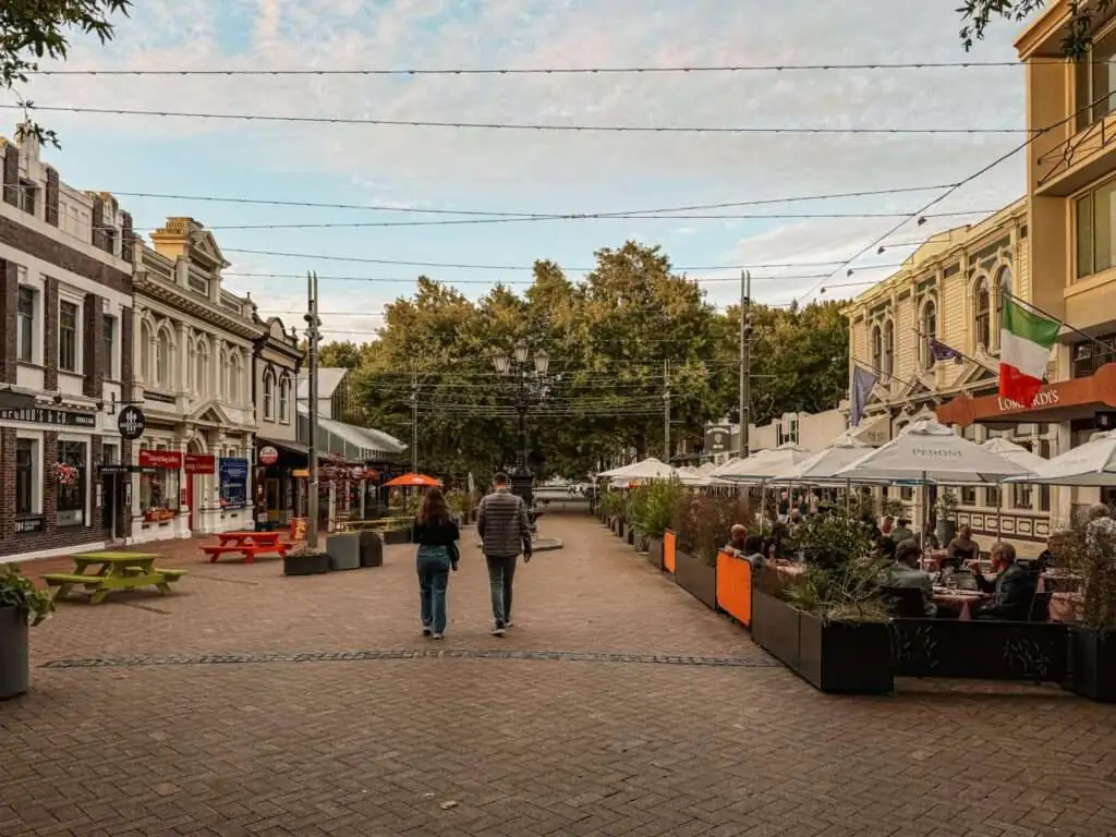 People walking down a pedestrian street with restaurant awnings on either side