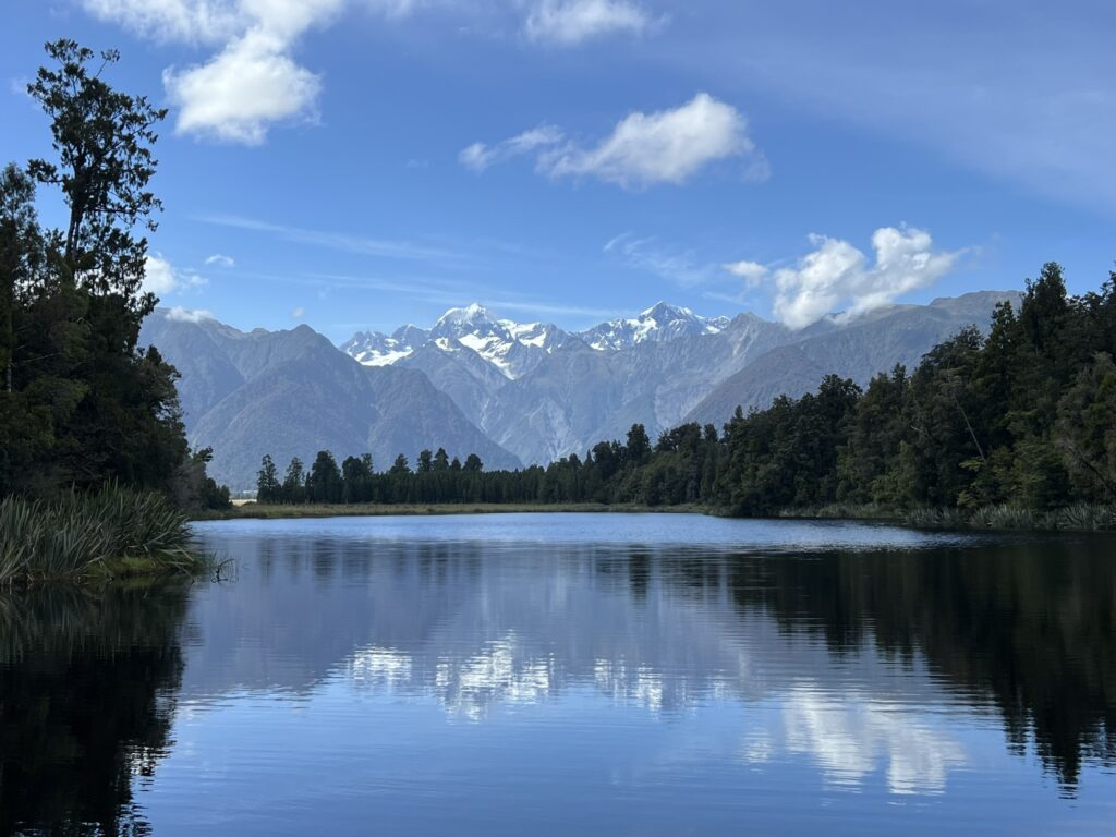 A lake that reflects the surrounding Southern Alps mountains