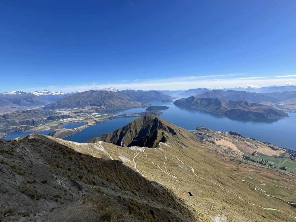 The edge of a mountain overlooking a lake within mountains near the Southern Alps