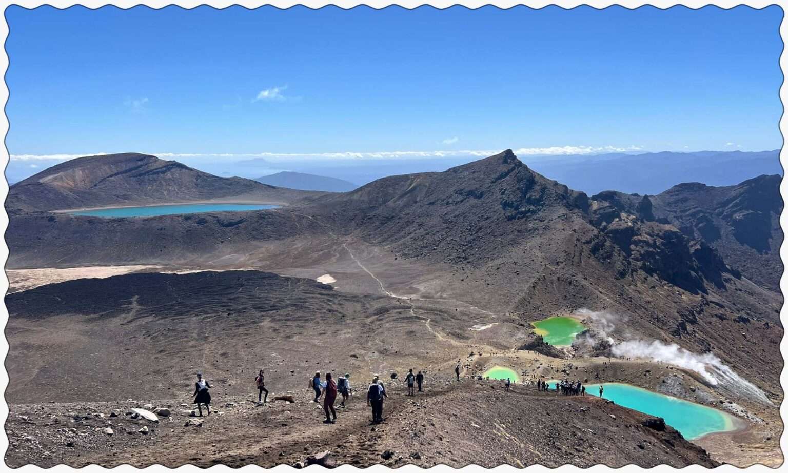 Turquoise pools nestled into the valley of a red rocky mountain outside of Taupo