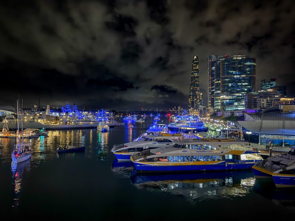 Boats in a large city dock at night with boats moving through water after the New Year's Eve fireworks