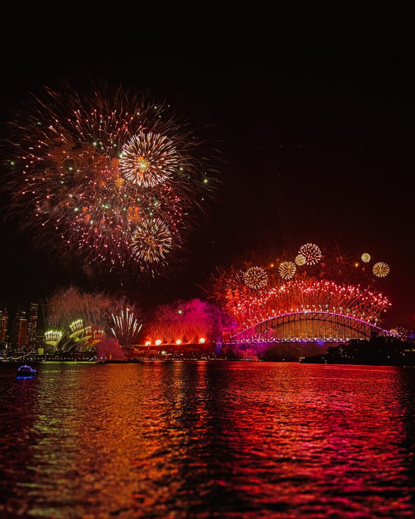 A red firework show over the city skyline of Sydney for New Year's Eve