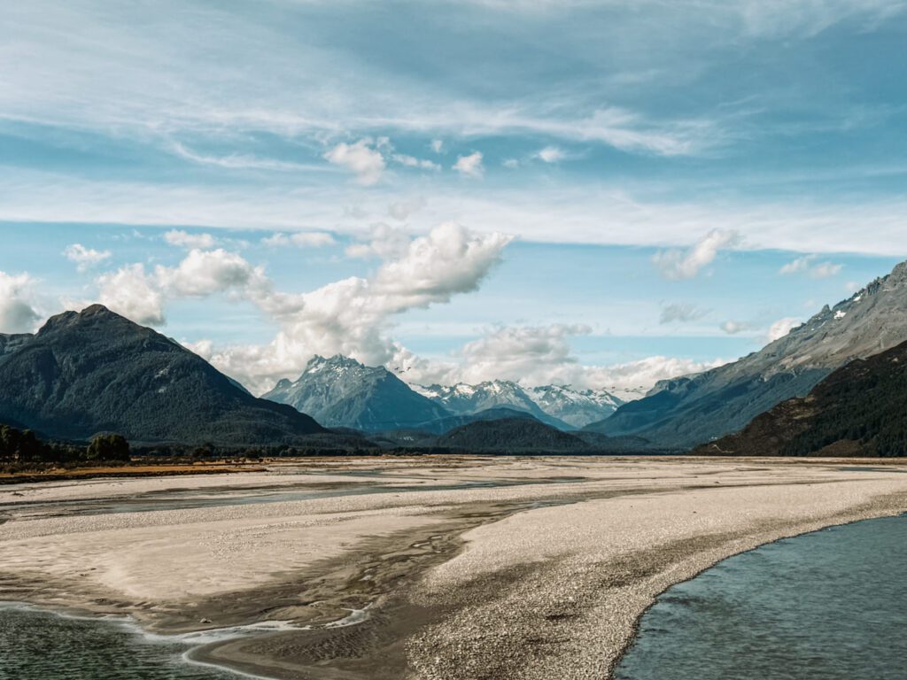 the basin of a river with mountains in the background used as one of the filming locations in the Lord of the Rings