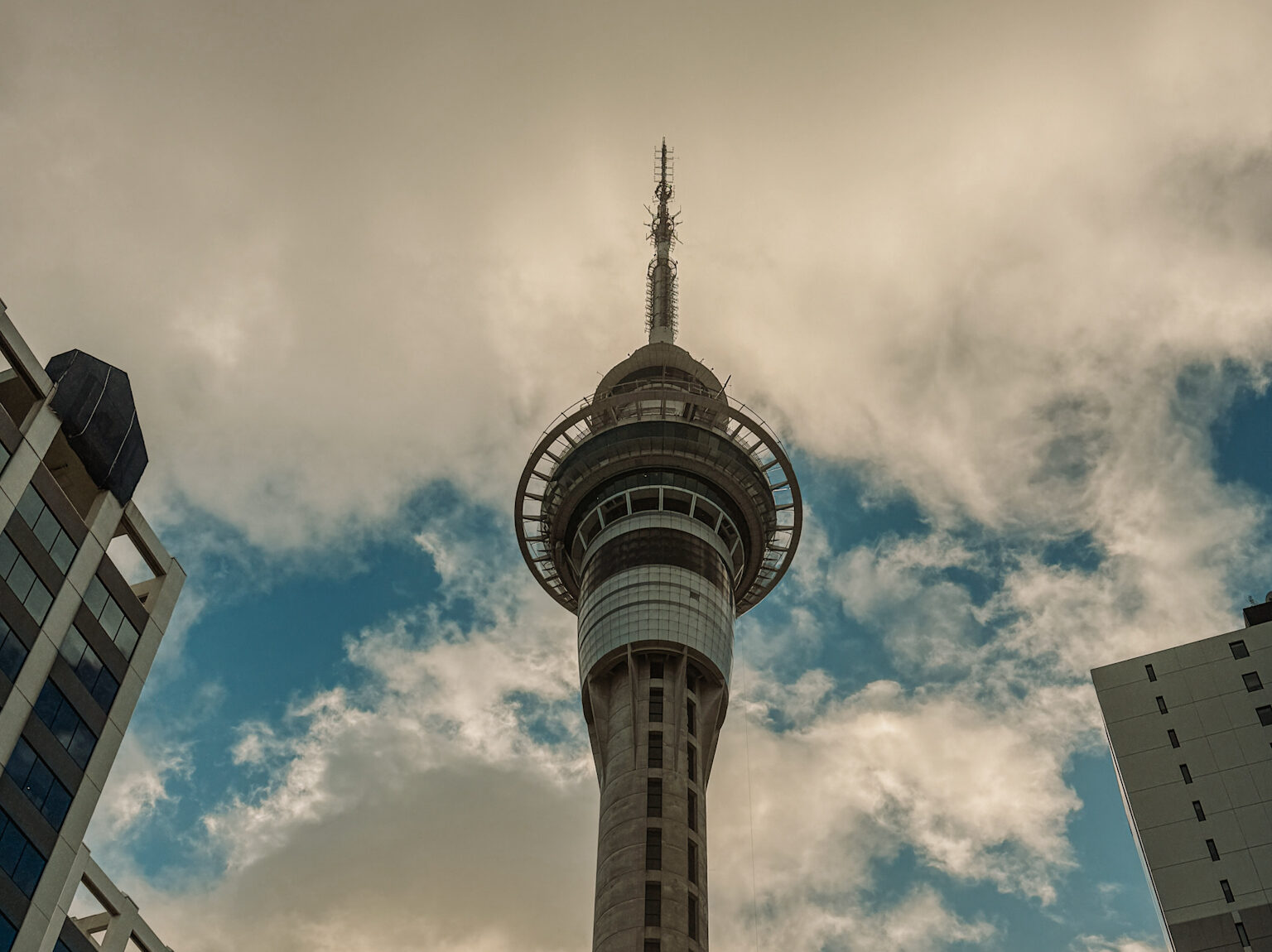 A view up to the Sky tower surrounded by other buildings as part of an Auckland itinerary for a weekend in Auckland