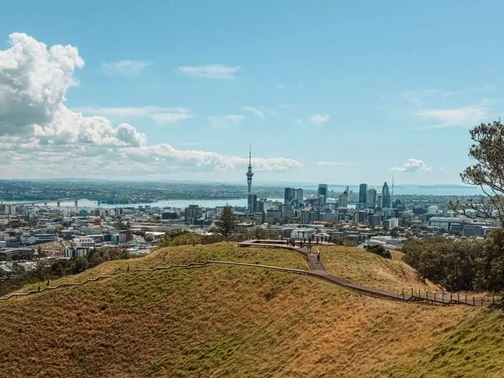 Looking over a wide grassy crater with a city skyline in the background as part of an Auckland itinerary for a weekend in Auckland