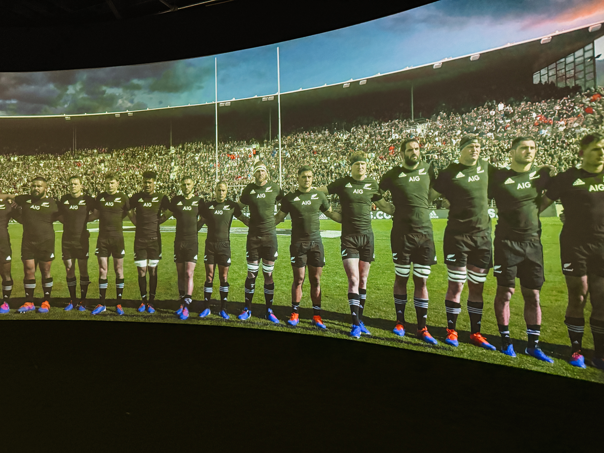 People linked arms in a line on a panoramic screen part of an Auckland itinerary for a weekend in Auckland