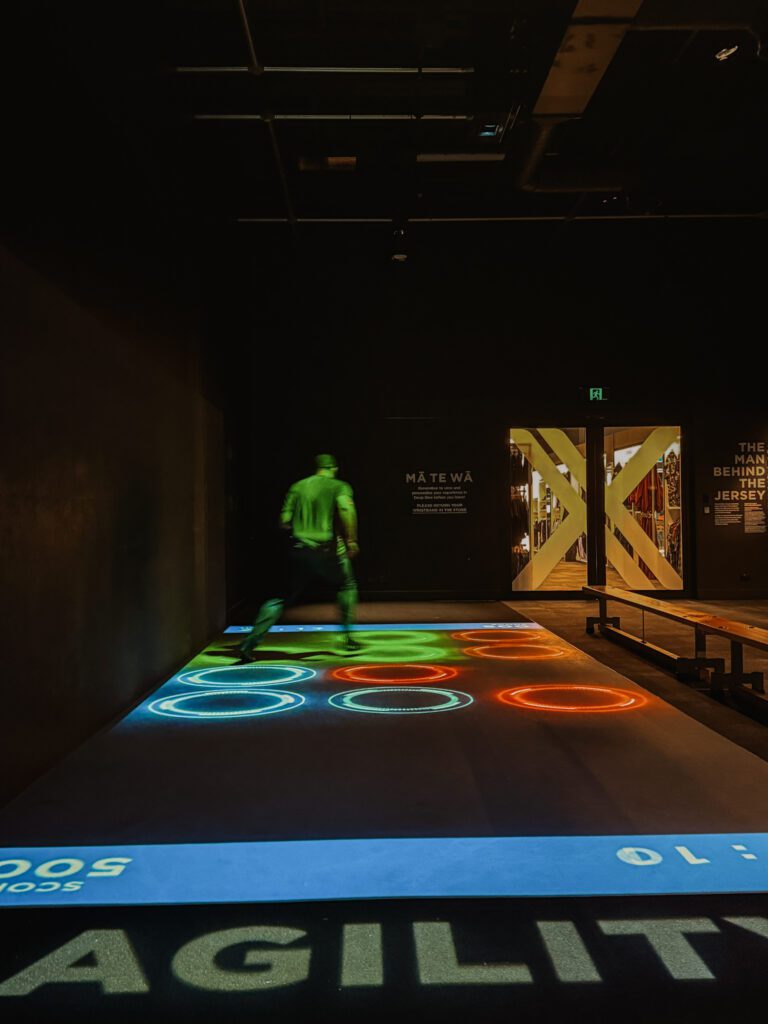 A man hopping on a screen with red and green circles in Auckland