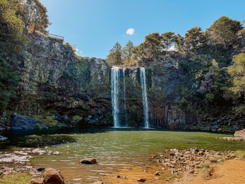 A waterfall flowing into a small lake in the Northland area of New Zealand