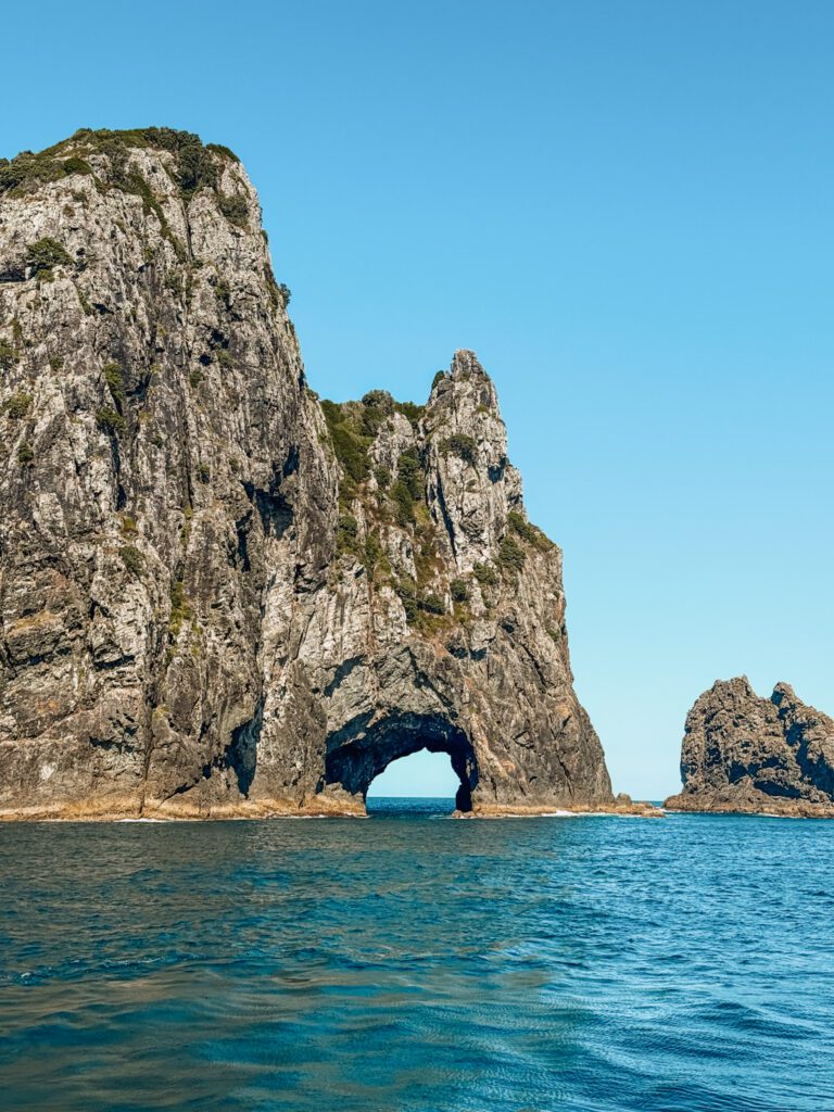 A large rock with a cave going through part of it while in the Northland area of New Zealand