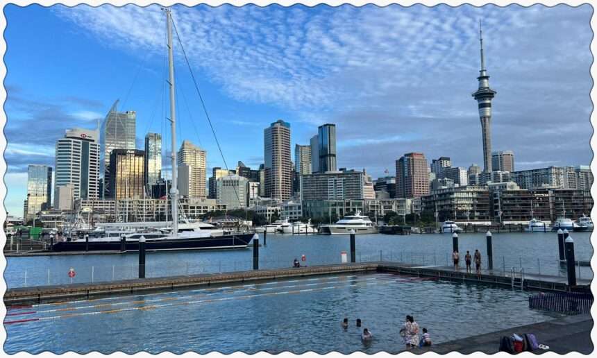 A pool in a harbor with a city in the background in Auckland, New Zealand