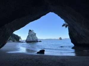 A view through a cave of a rock formation in the water of the Coromandel Peninsula