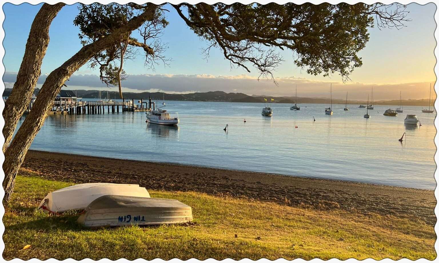 the sun setting over a bay with boats in it
