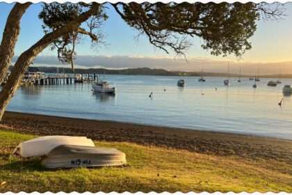 the sun setting over a bay with boats in it