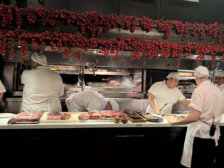 Chefs cooking behind a counter of a restaurant - Argentina food and drinks