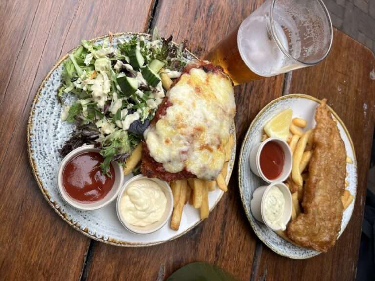 Two plates of food and a glass of beer - australia food and drinks
