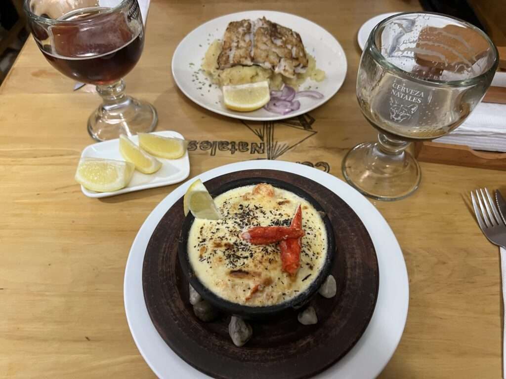 Plates of soup and food and some glasses of wine - Chile food