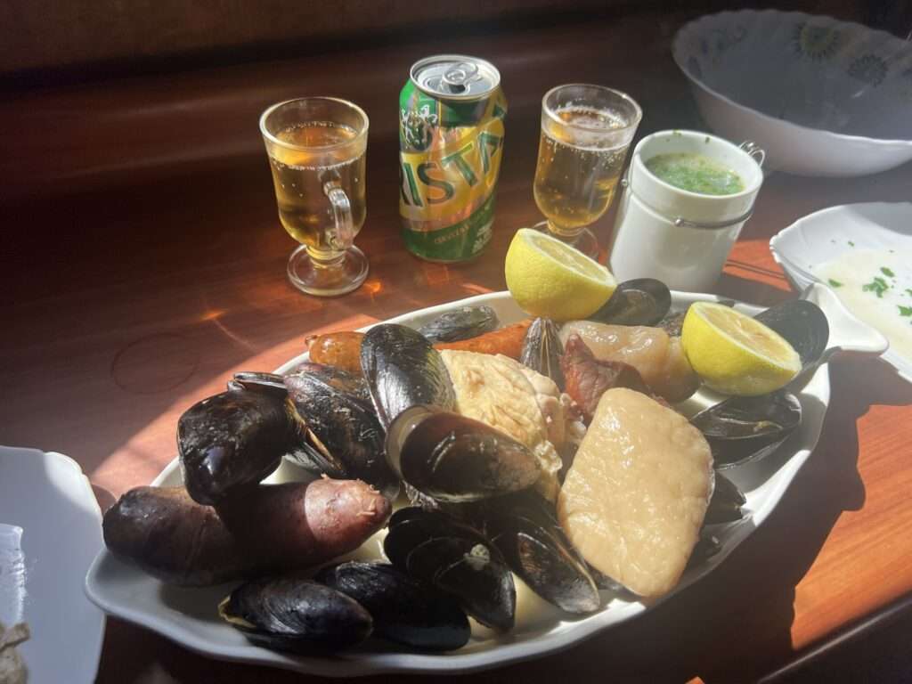A long plate with seafood, sausage, and chicken on it - Chile food
