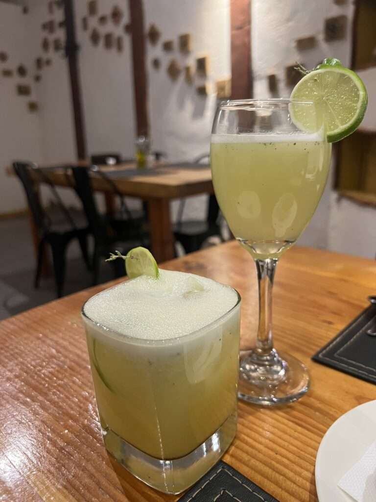 Two cups of a yellow cocktail on a table - Chile food
