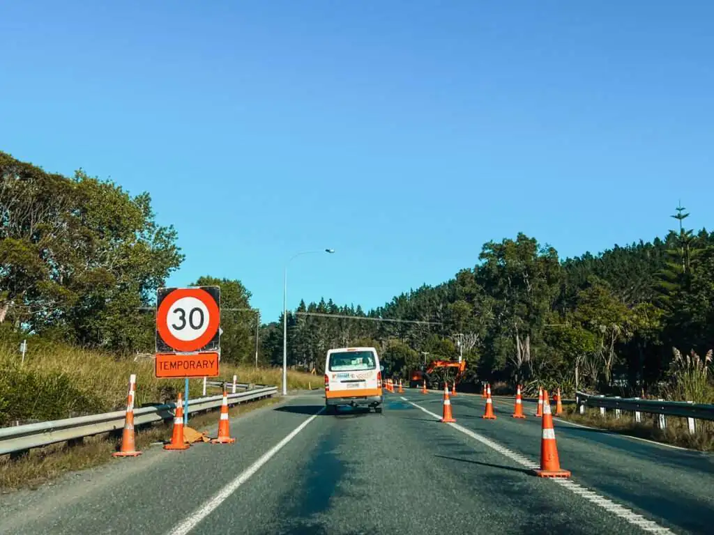 A road with many traffic cones and a speed limit indicator and a good example of where you may consider is New Zealand safe when it comes to driving