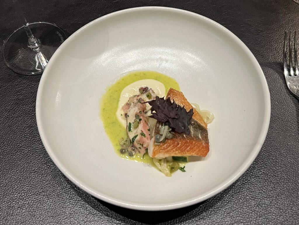 A plate with salmon in the center to represent new zealand food and drink