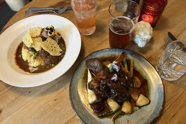 A table with two meals of lamb on a table of popular New Zealand food and drinks
