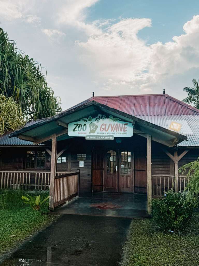 The entrance to a building with a sign saying Zoo of Guiana as part of the French Guiana itinerary