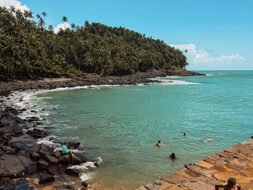 People swimming in a small cove off of a tropical island as one of the things to do in Kourou