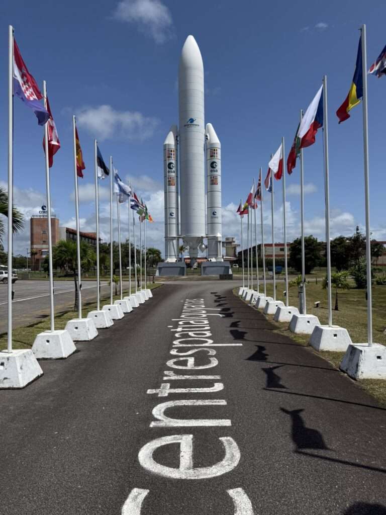 A road lined with flags leading to a rocket in French Guiana