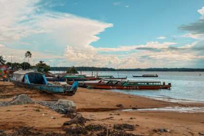 Some long wooden pirogues on the banks of a river used to cross the border between French Guiana and Suriname