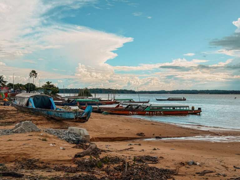 Some long wooden pirogues on the banks of a river used to cross the border between French Guiana and Suriname