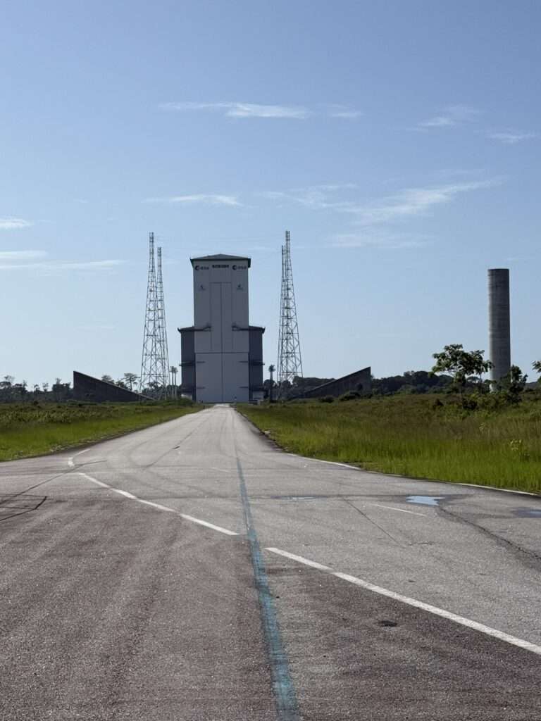 A road to a very tall building out of which rockets are launched in French Guiana
