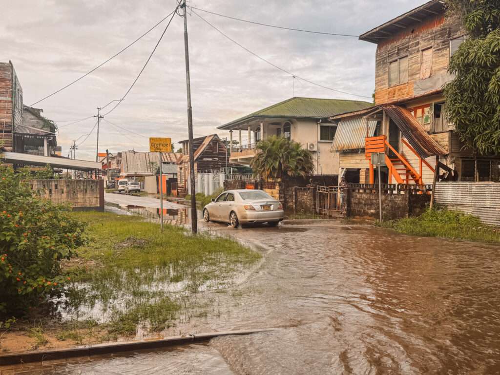 A road that is flooded in a neighborhood in Suriname